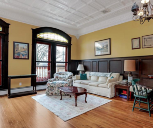 The second-floor studio is accessed via the original oak staircase or via elevator and opens to a living room with a fireplace. French doors framed by stain-glass windows open to a restored balcony overlooking Main Street.
