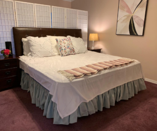 Although the home owners weren't in love with the existing carpet, we decided to keep the bedding white and use complimentary mauve colors in the pillows and throws. 