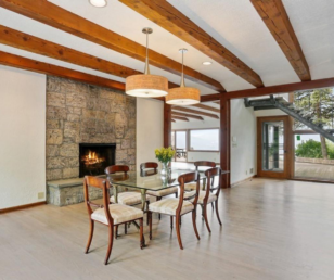The dining area features abundant natural light and a stone fireplace to create a warmth for the room. 